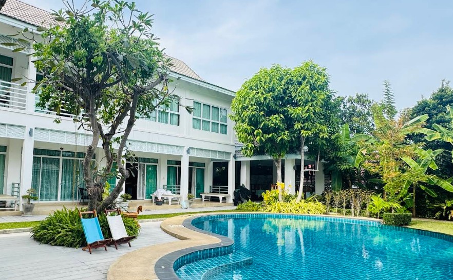 สระว่ายน้ำกลางแจ้งและอาคารที่พักสีขาวในบรรยากาศร่มรื่นที่ Baan Jeen Hotel Samroiyod Beach หาดสามร้อยยอด