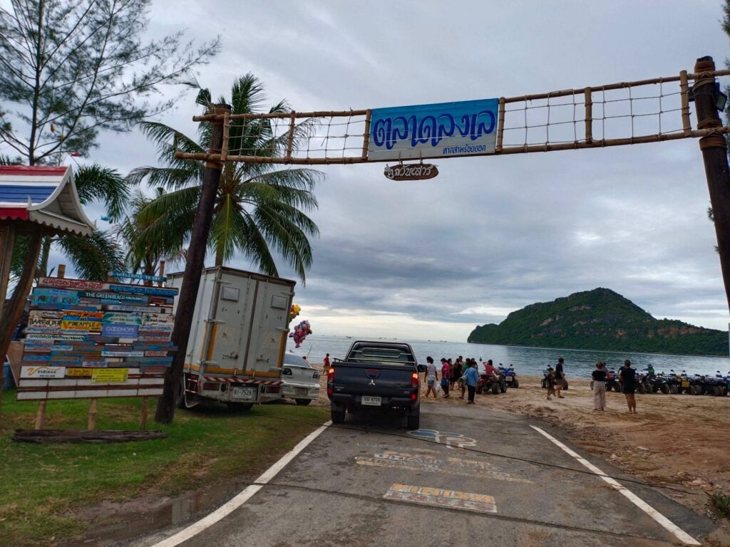 ซุ้มประตูทางเข้าตลาดลงเล ชายหาดสามร้อยยอด มองเห็นวิวทะเลและเกาะนมสาวในวันฟ้าครึ้มสบายๆ